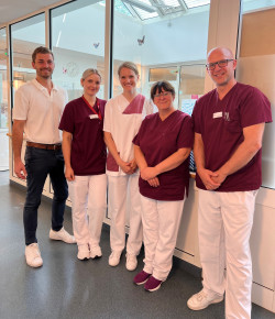 Mitten im Team mit Therapieleiter Philipp Schneider (li), Pflegedirektor Nico Kleine-Knefelkamp (re) und Pflegekräften | © Kliniken Beelitz